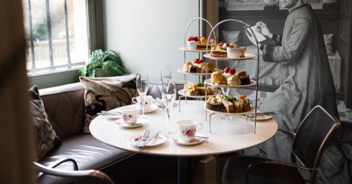 Table inside Cafe Bowes set up with Afternoon Tea food and drinks.